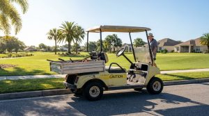 man operating utility golf cart with CAUTION label on residential street near golf course